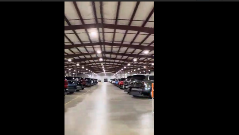Interior of a large warehouse with cars parked inside