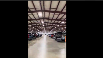 Interior of a large warehouse with cars parked inside