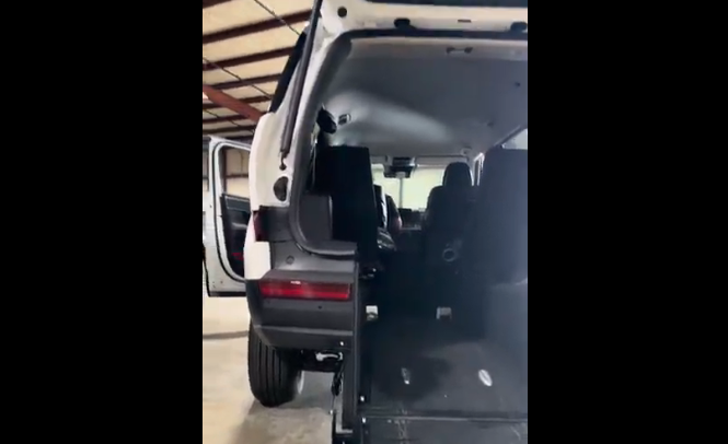 Van interior with open door and back seat in a garage setting