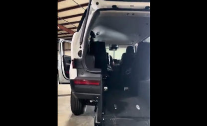 Van interior with open door and back seat in a garage setting